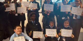Children holding up certificates